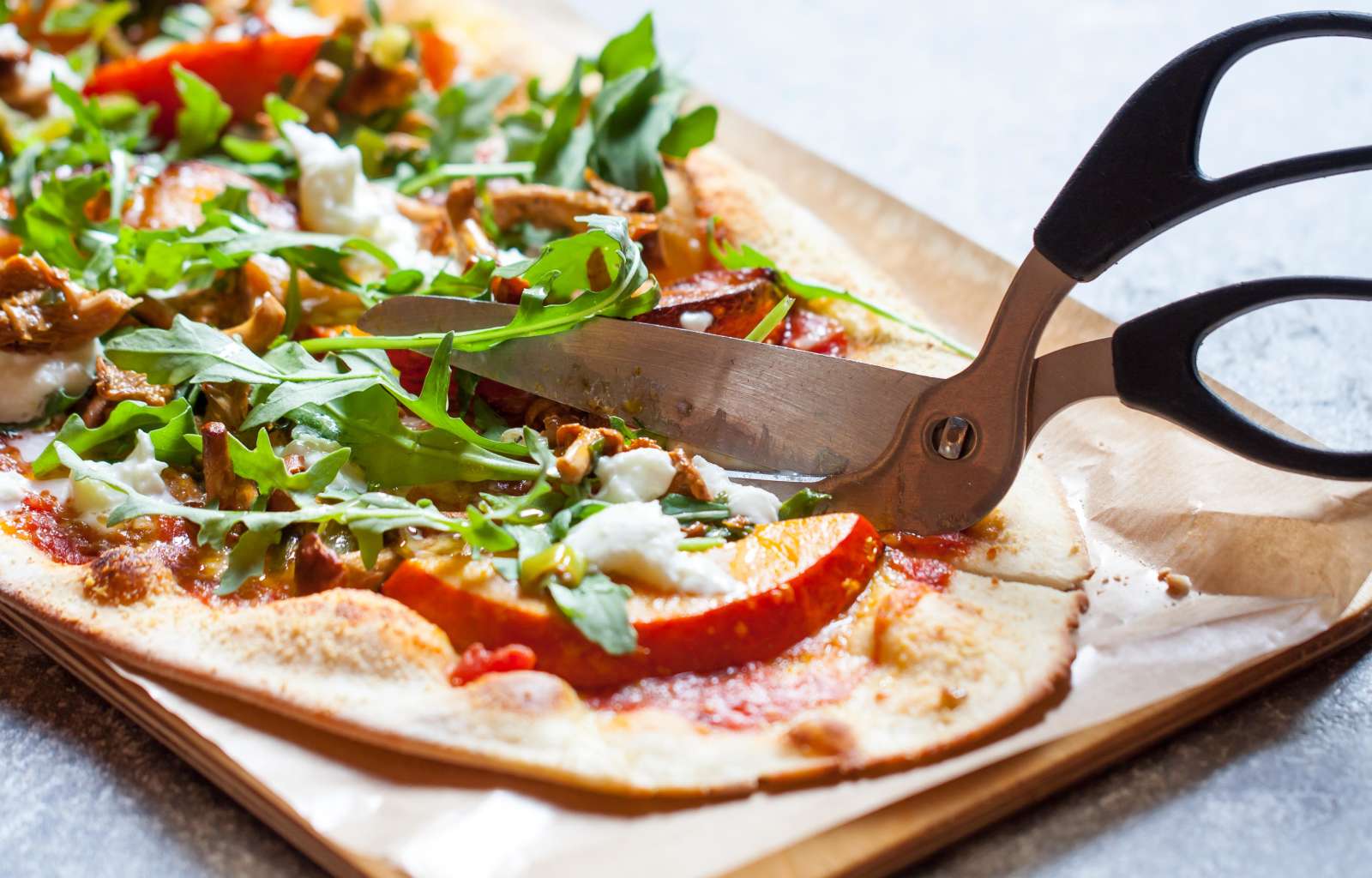 Marché Pizza mit Schere auf Pizzabrett