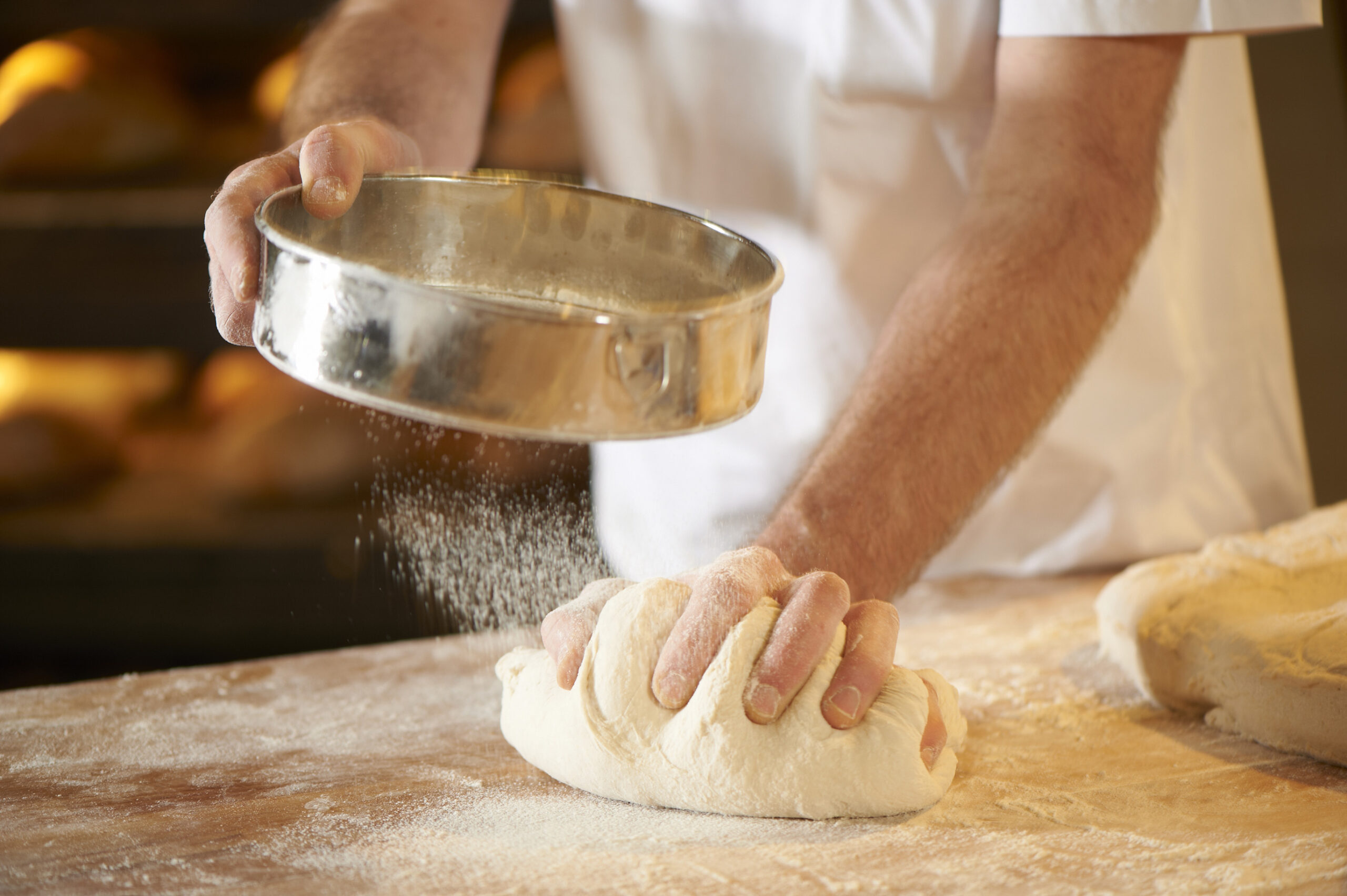 Brotteig wird mit Mehl geknetet