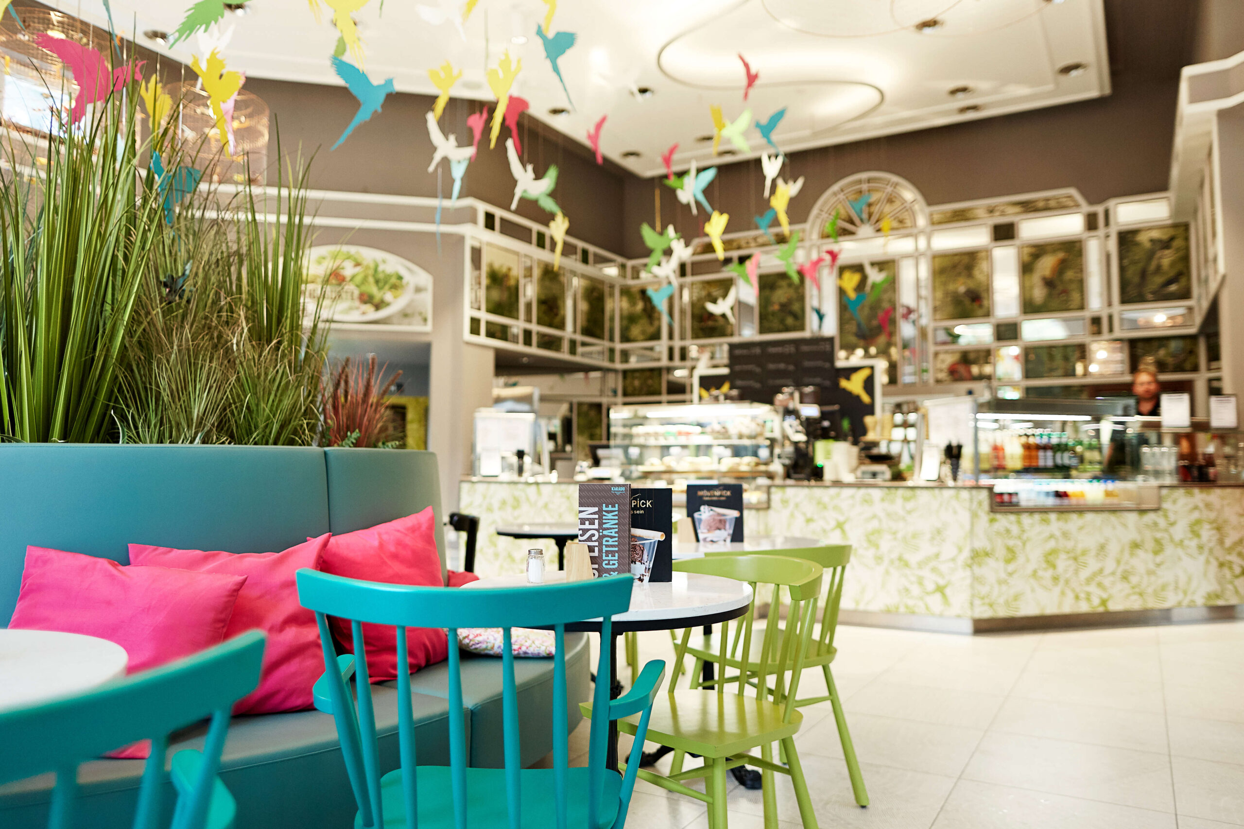 Kakadu Tierpark Berlin Sitzbereich innen mit Stühlen, Tischen und Vogeldeko